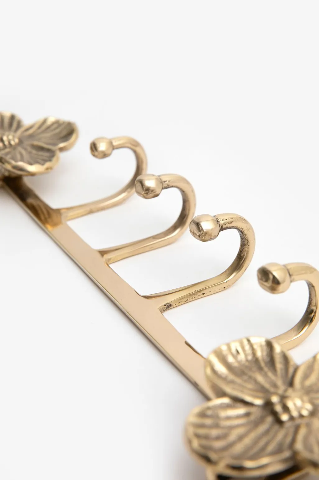 Goudkleurige kapstokhaken met bloemen