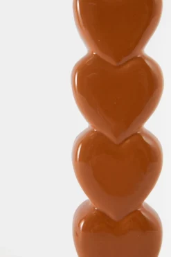 Oranje kandelaar met opgestapelde hartjes