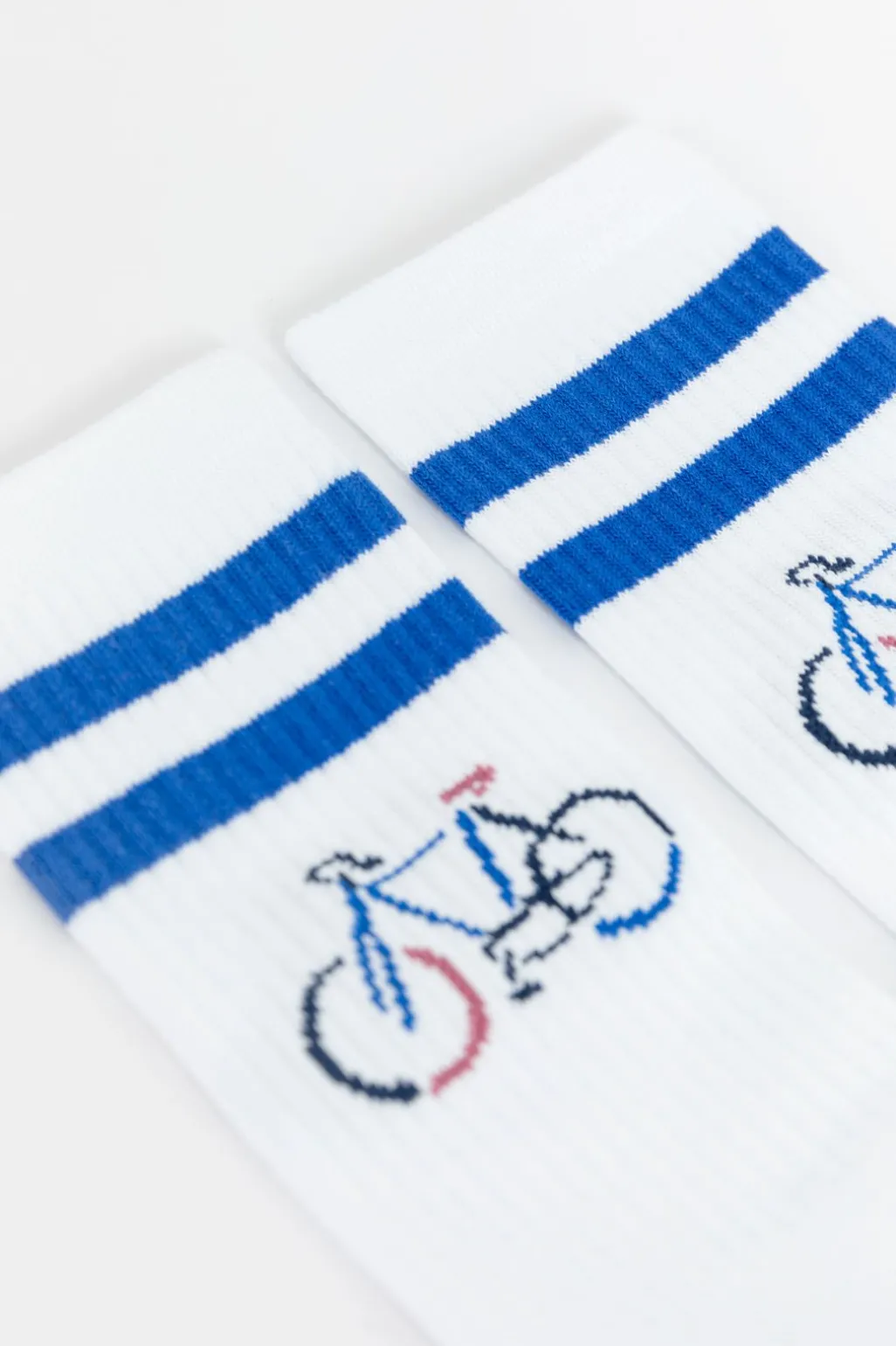 Witte sportsokken met blauwe strepen en fiets
