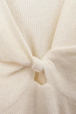 Witte trui met gedraaide knoop